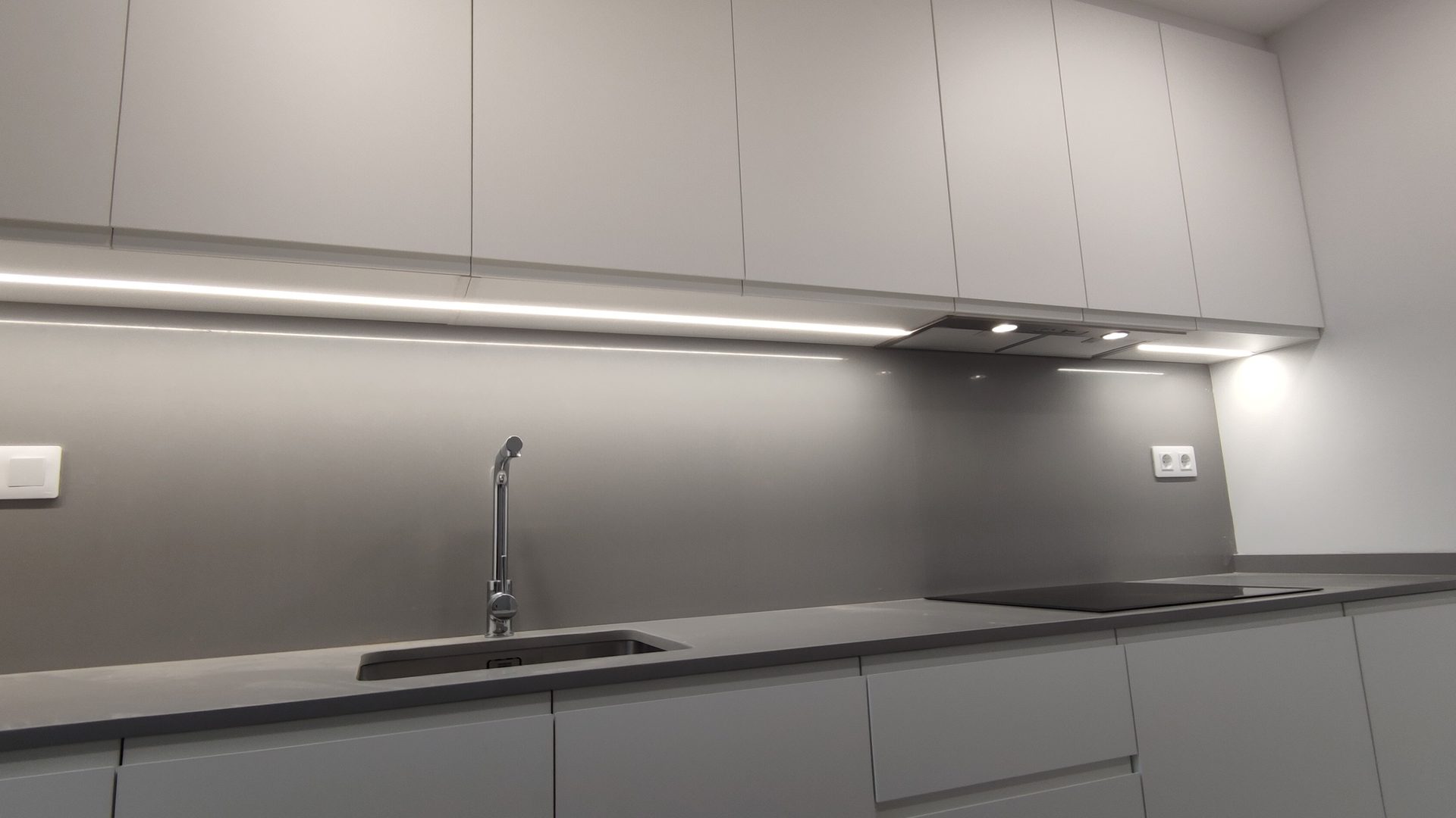 Cocina a medida en gris con iluminación LED bajo los muebles altos