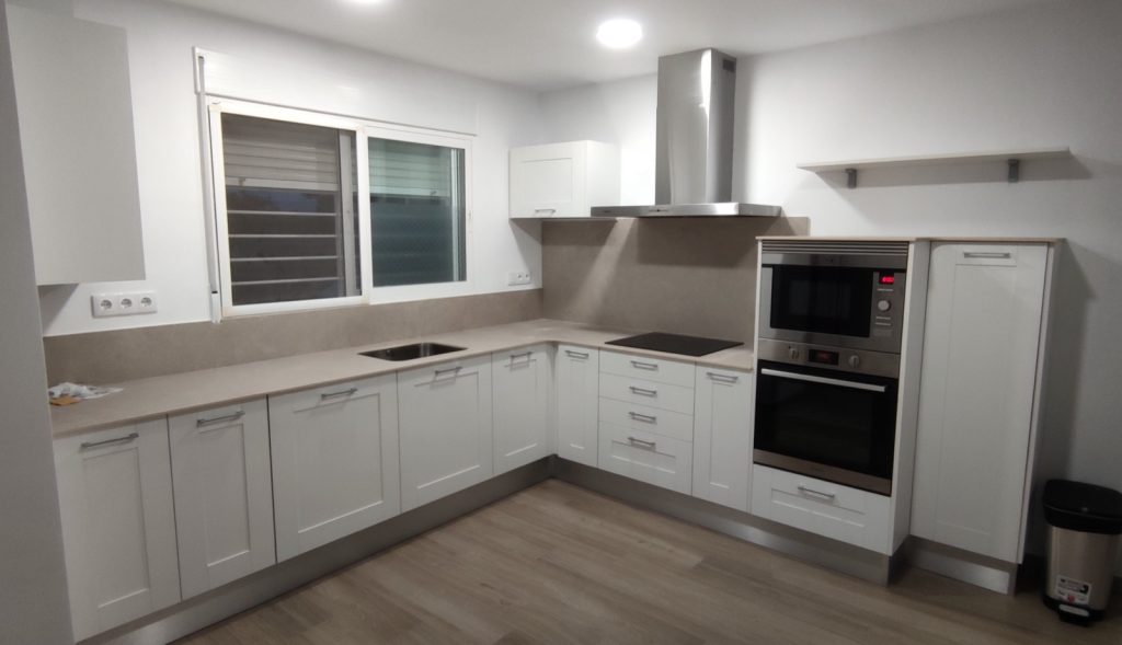 Cocina a medida blanca con encimera de mármol e iluminación LED en Valencia