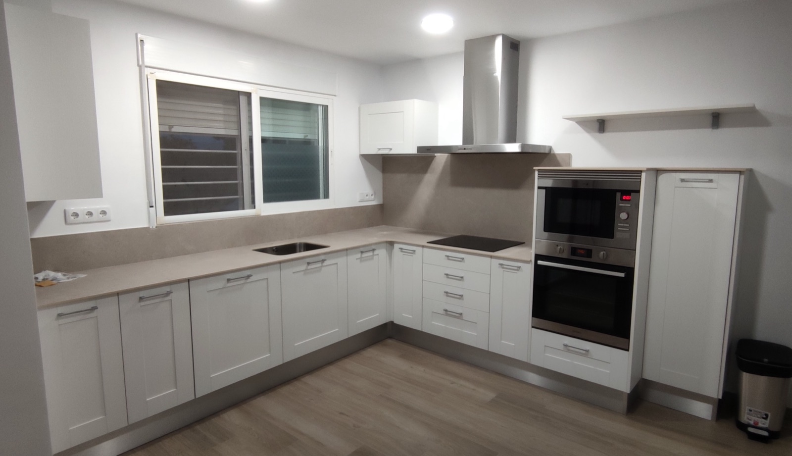 Cocina a medida blanca con encimera clara en Valencia