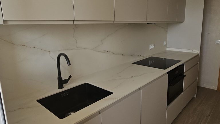Encimera de cocina a medida con grifo negro y frente de mármol en Valencia